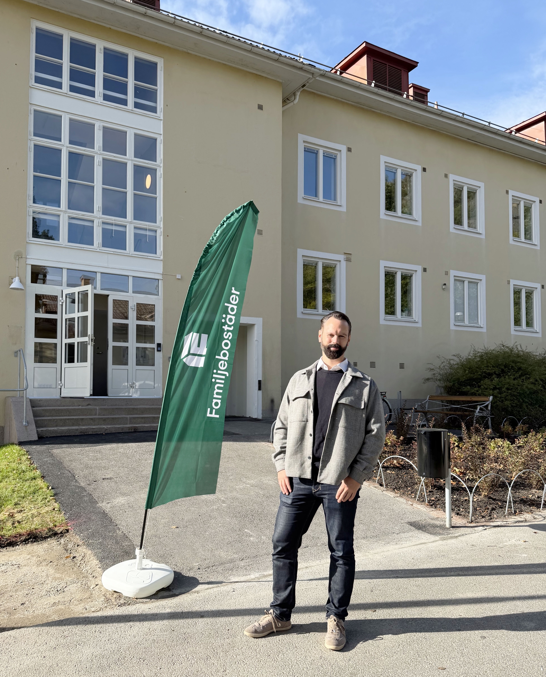 Bild på en man som står framför ett ljusgult flerfamiljshus i Fjällbo.